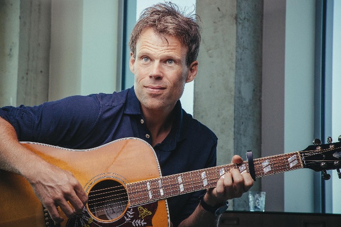 Jaap Kwakman met akoestische gitaar bij Sixstrings